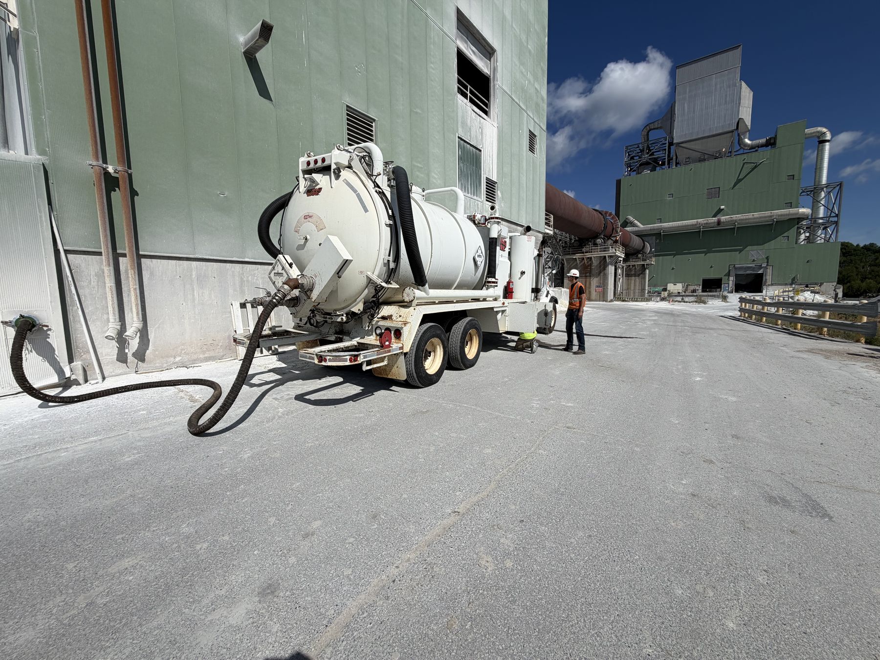 A Walker Centrifuge Services vacuum truck working alongside a kiln at an industrial plant